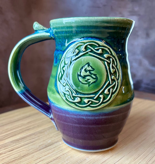 Hand throw ceramic mug with a medallion containing a Celtic knot and a fox in the center.