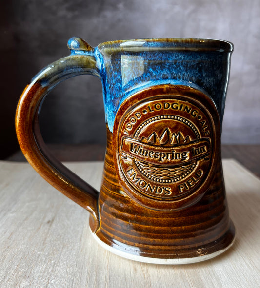 Hand thrown pottery tankard inspired by Jordan's Wheel of Time Series. The medallion includes Winespring Inn