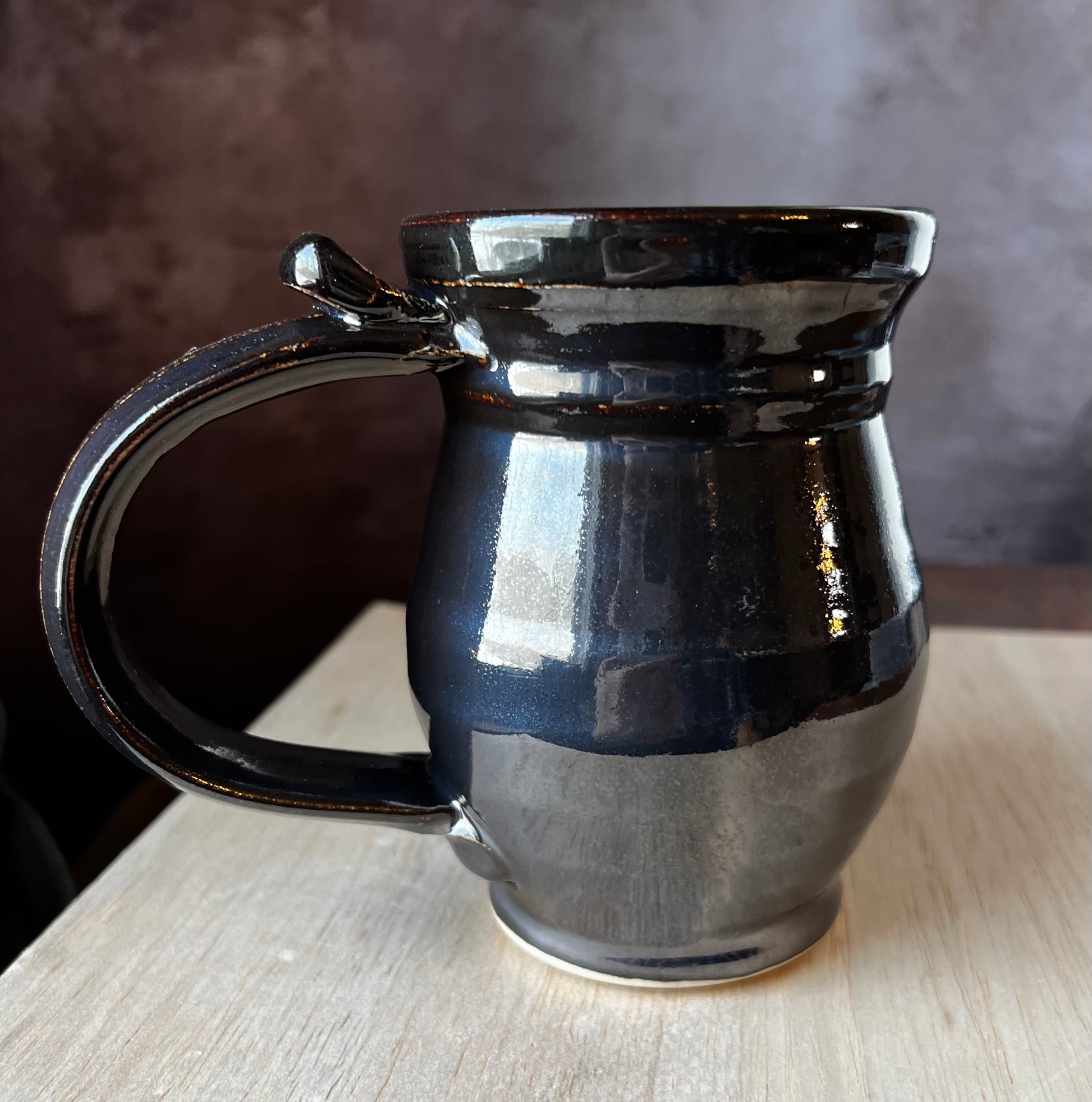 Black glazed Pottery mug for left handed people.