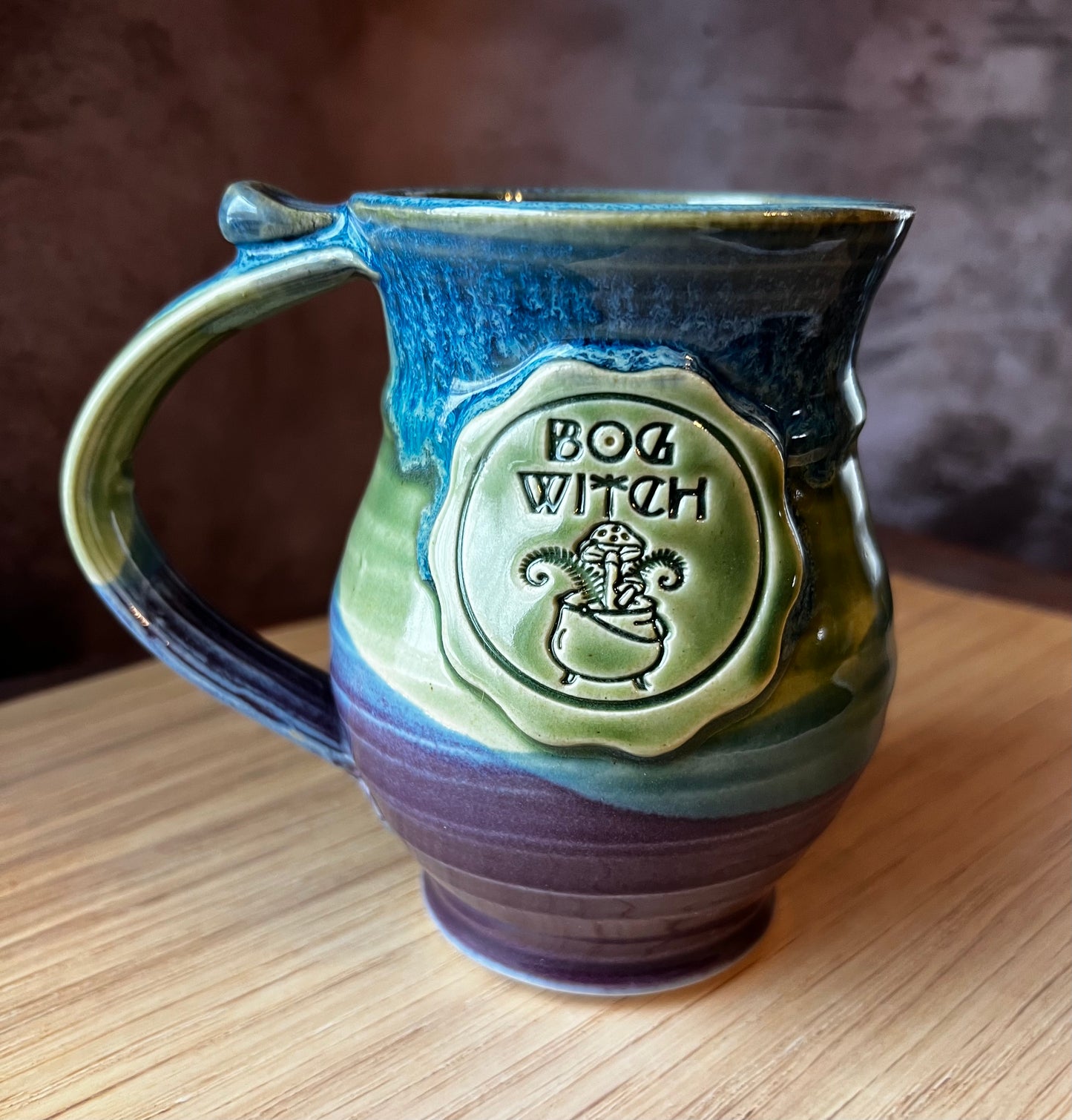 Hand thrown ceramic mug with a Bog Witch medallion.