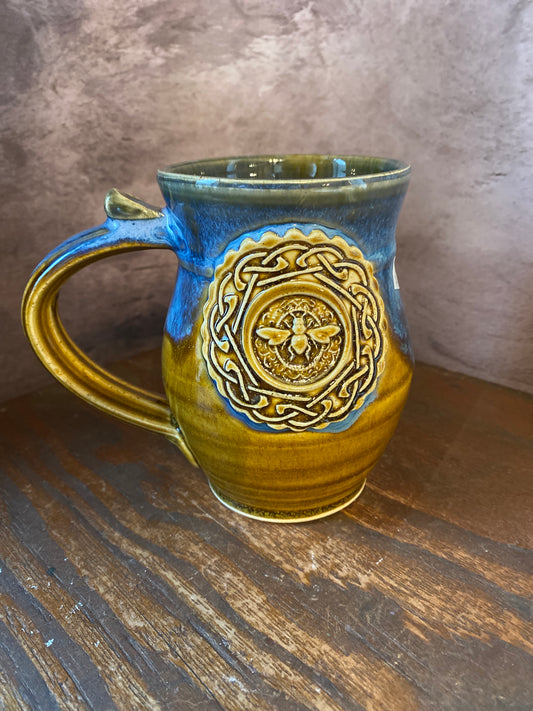 Ceramic mug with a Celtic knot surrounding a honey bee