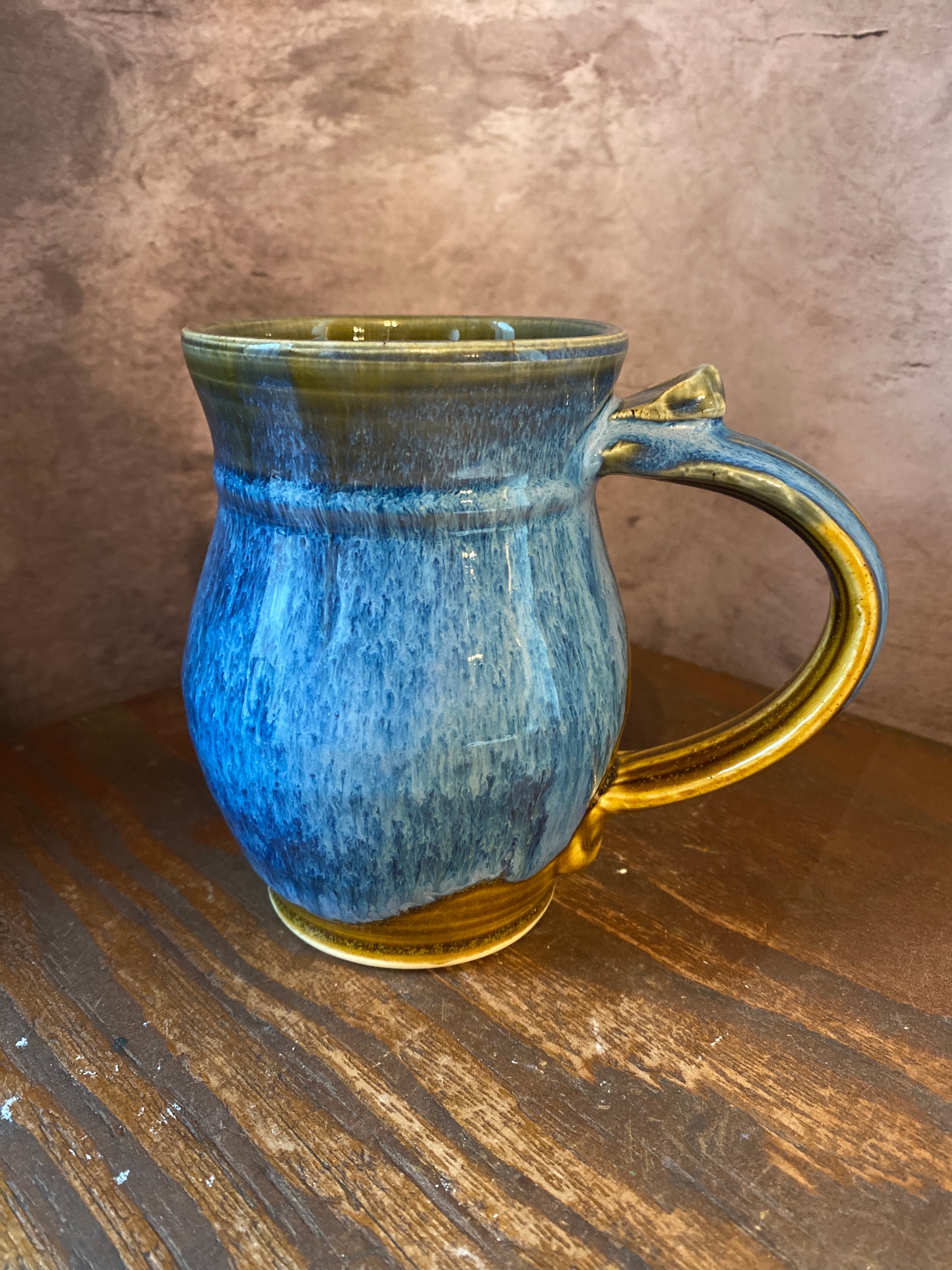 back of a hand thrown pottery mug with blues and browns