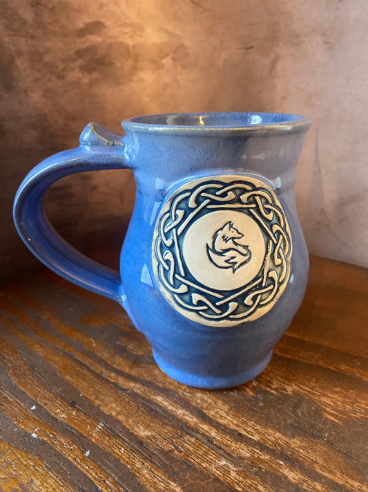 Blue glazed ceramic mug with Celtic knots and a fox medallion
