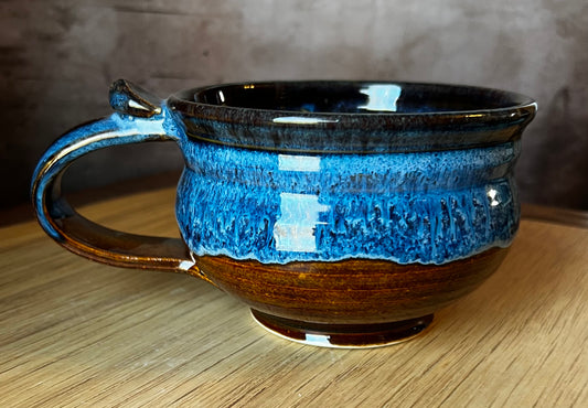 A generously-sized stoneware soup mug with a brown and blue color pattern, featuring a handle on the side