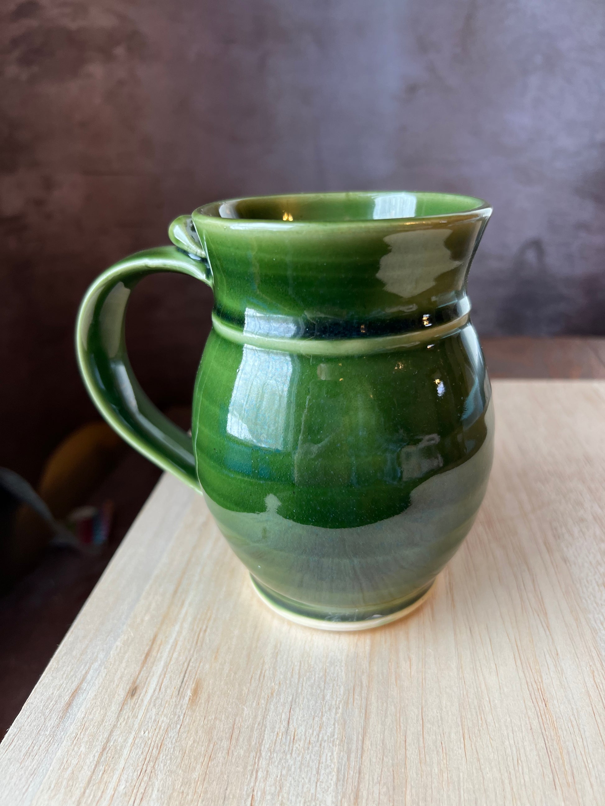 Back side of the left handed oak and acorn mug which is super glossy green.